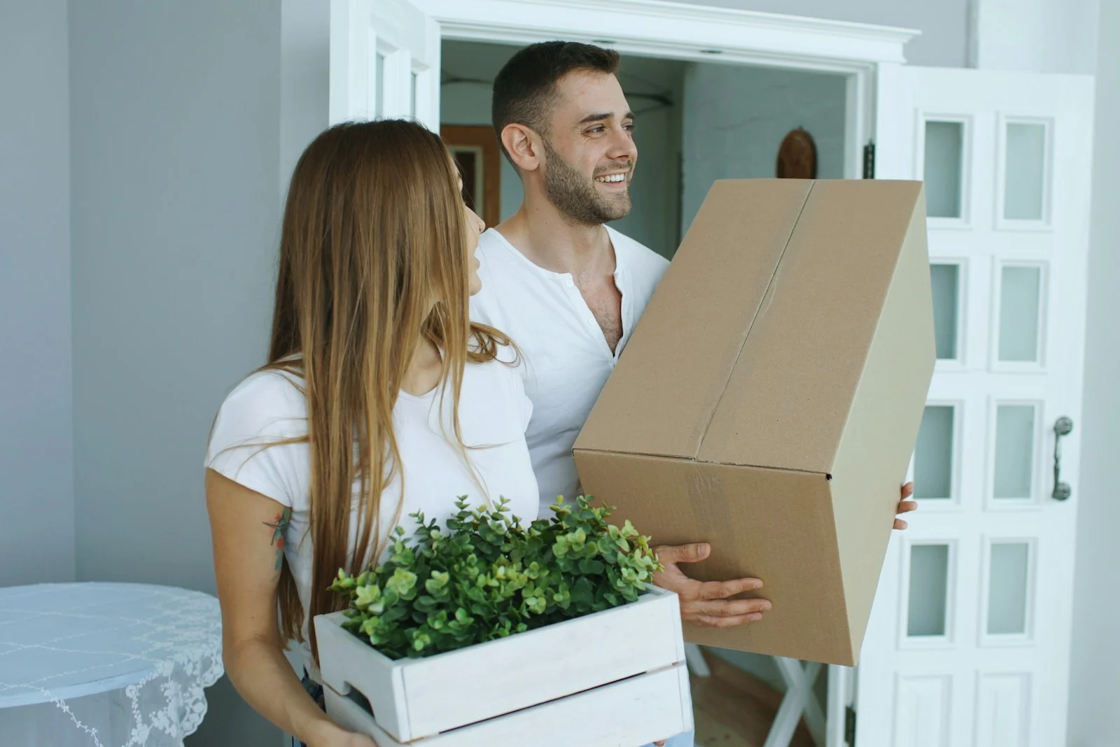 Junges Paar trägt Umzugskartons in die neue Wohnung